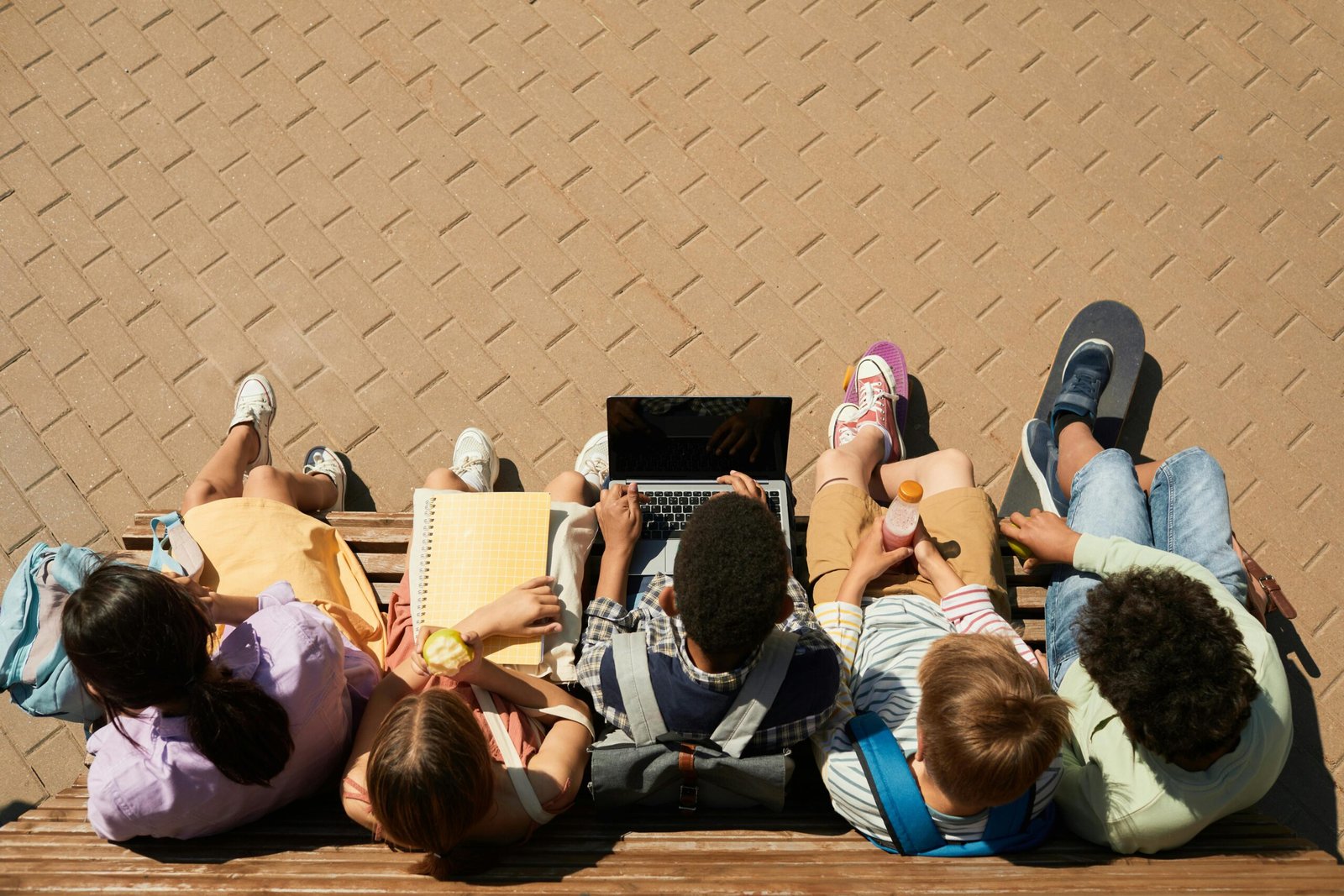 organized teens sitting together on a bench